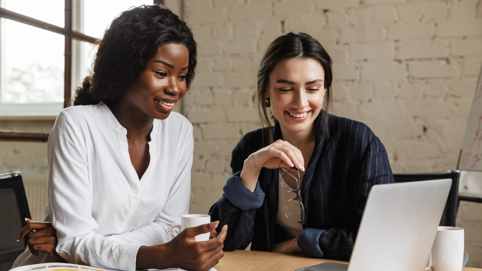 Two women discussing their Telecom Expense Management Audit