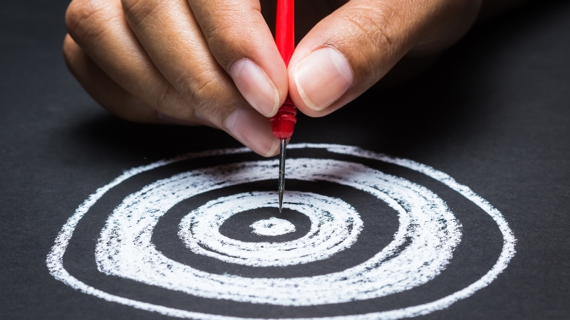 Person putting a dart in the bullseye